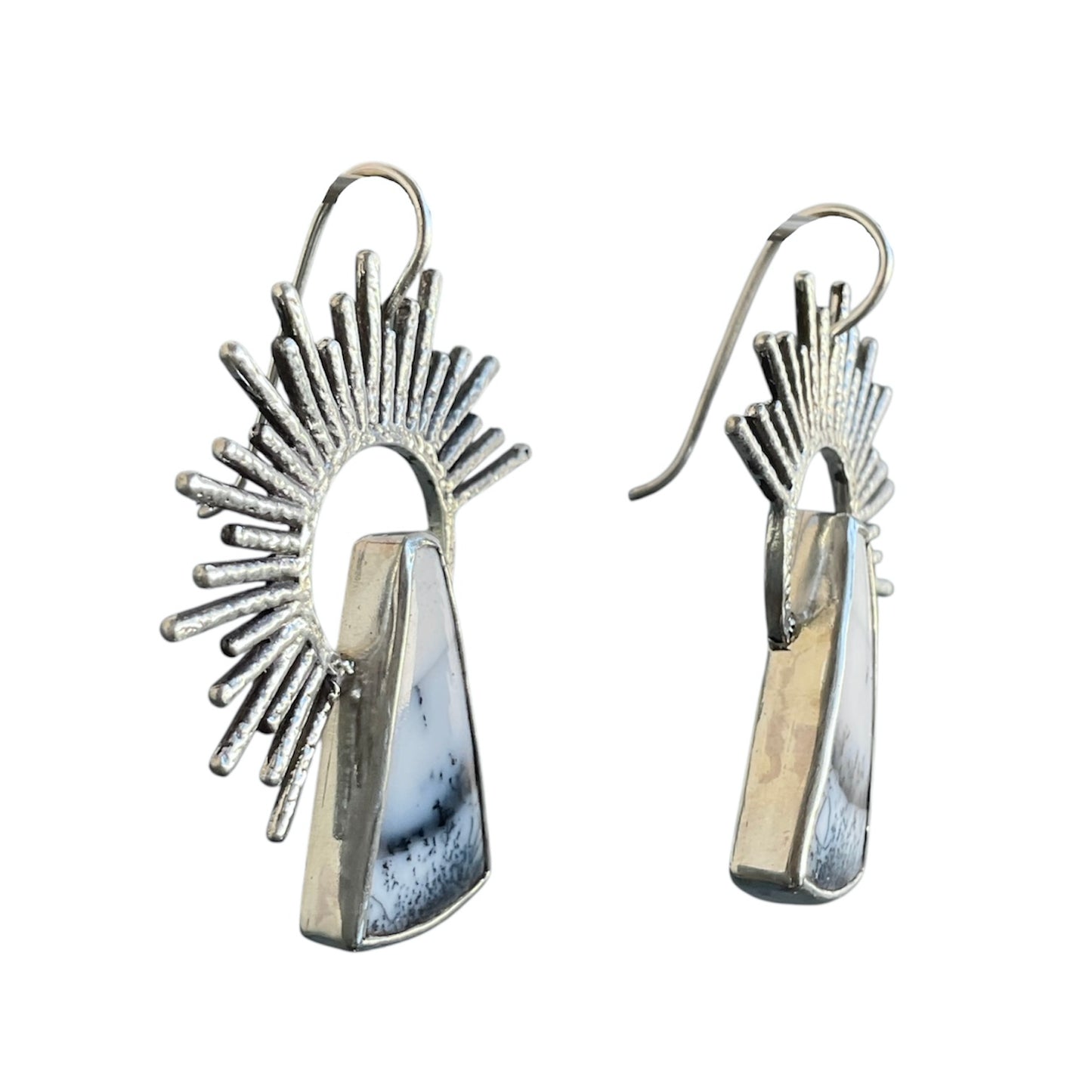 Silver earrings with sunburst design on a white background