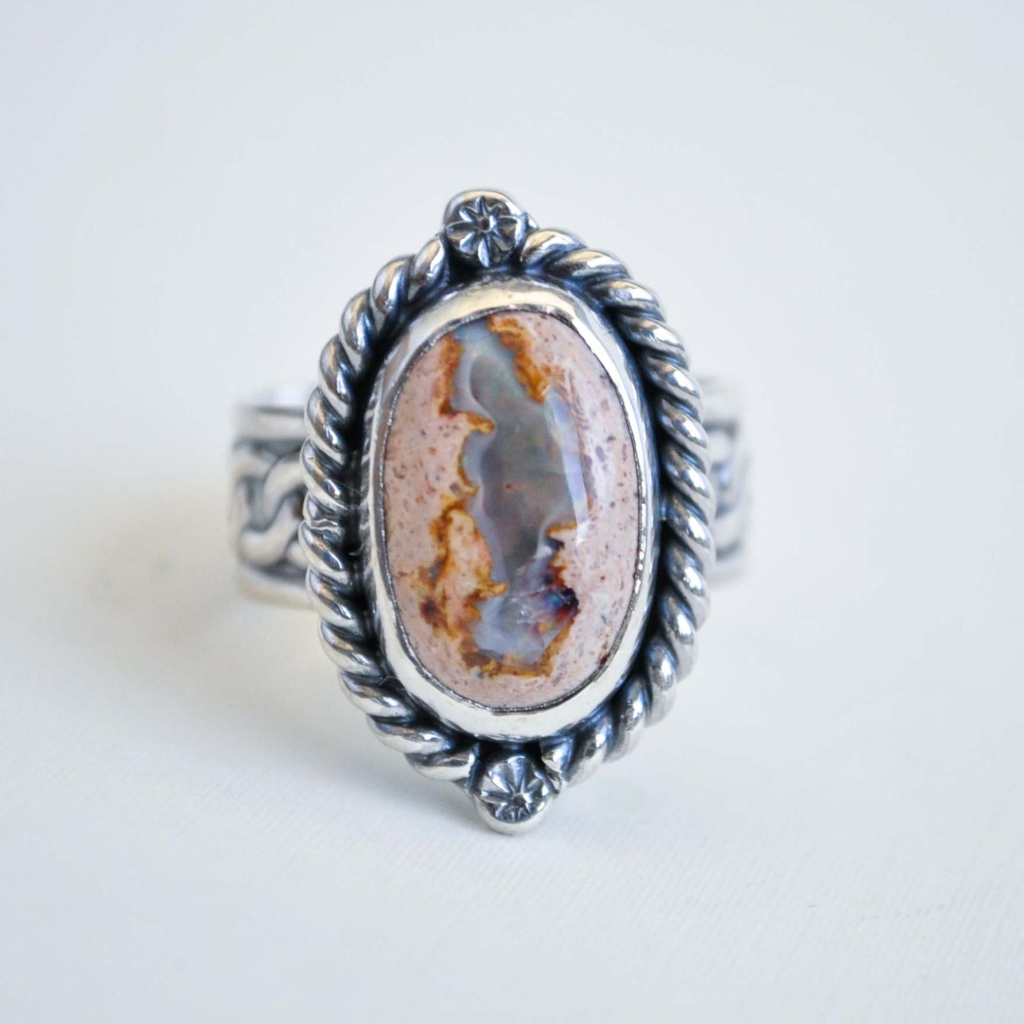 Silver ring with an oval stone on a white background