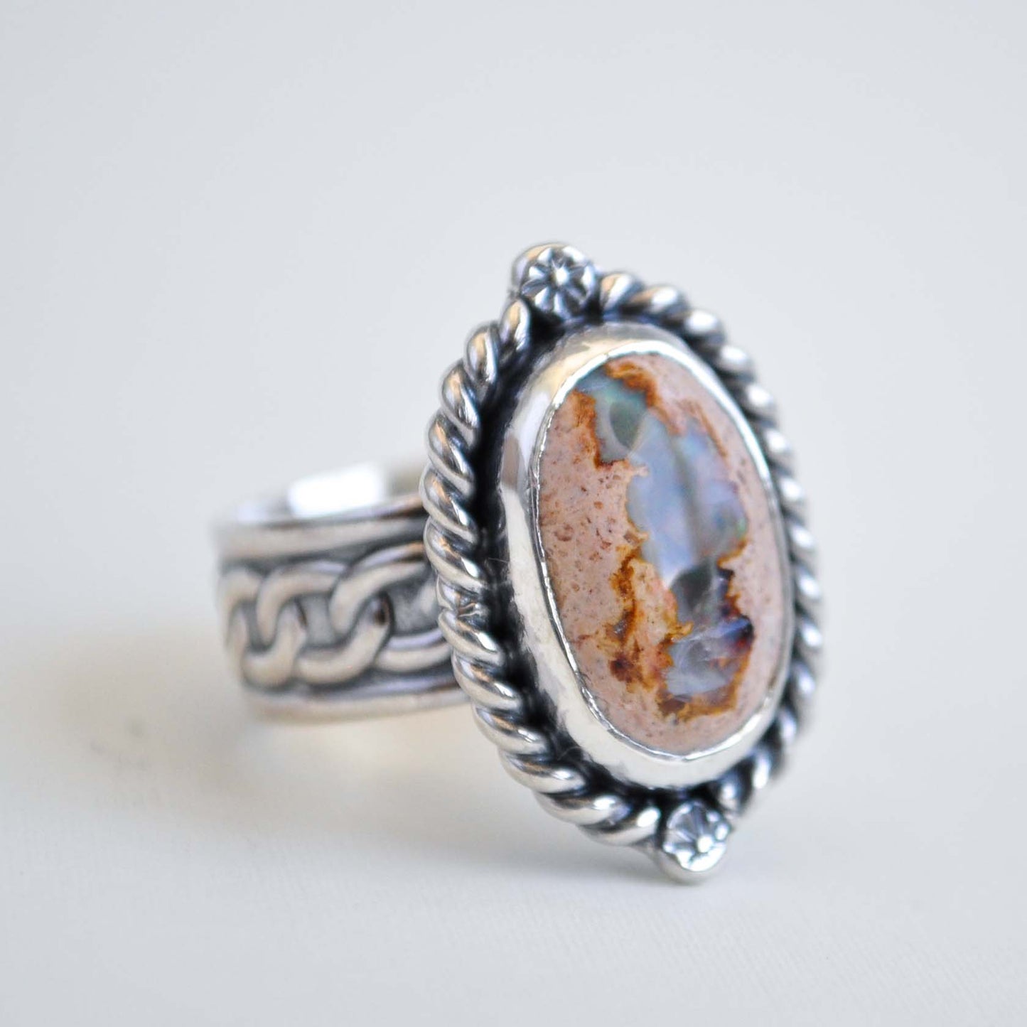 Silver ring with an oval stone on a light background