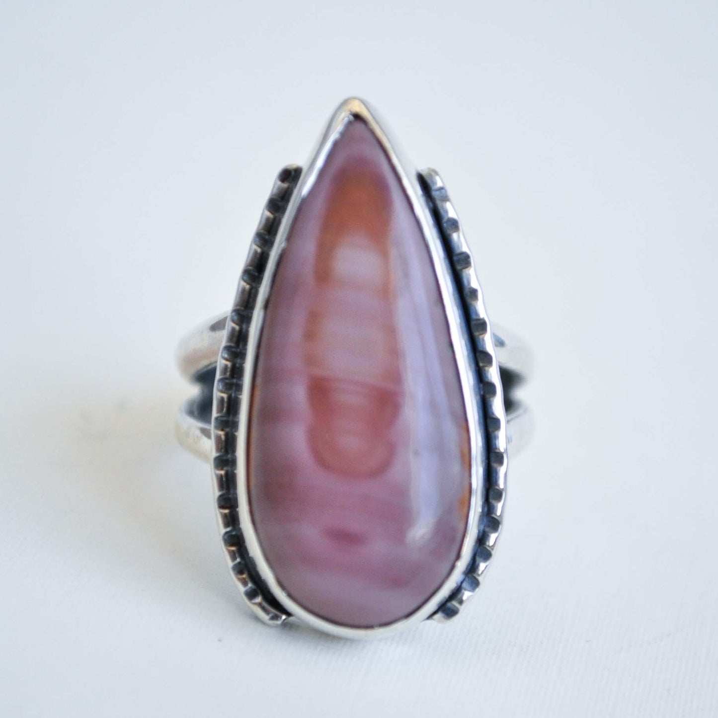 Ring with a large pink teardrop-shaped stone on a white background