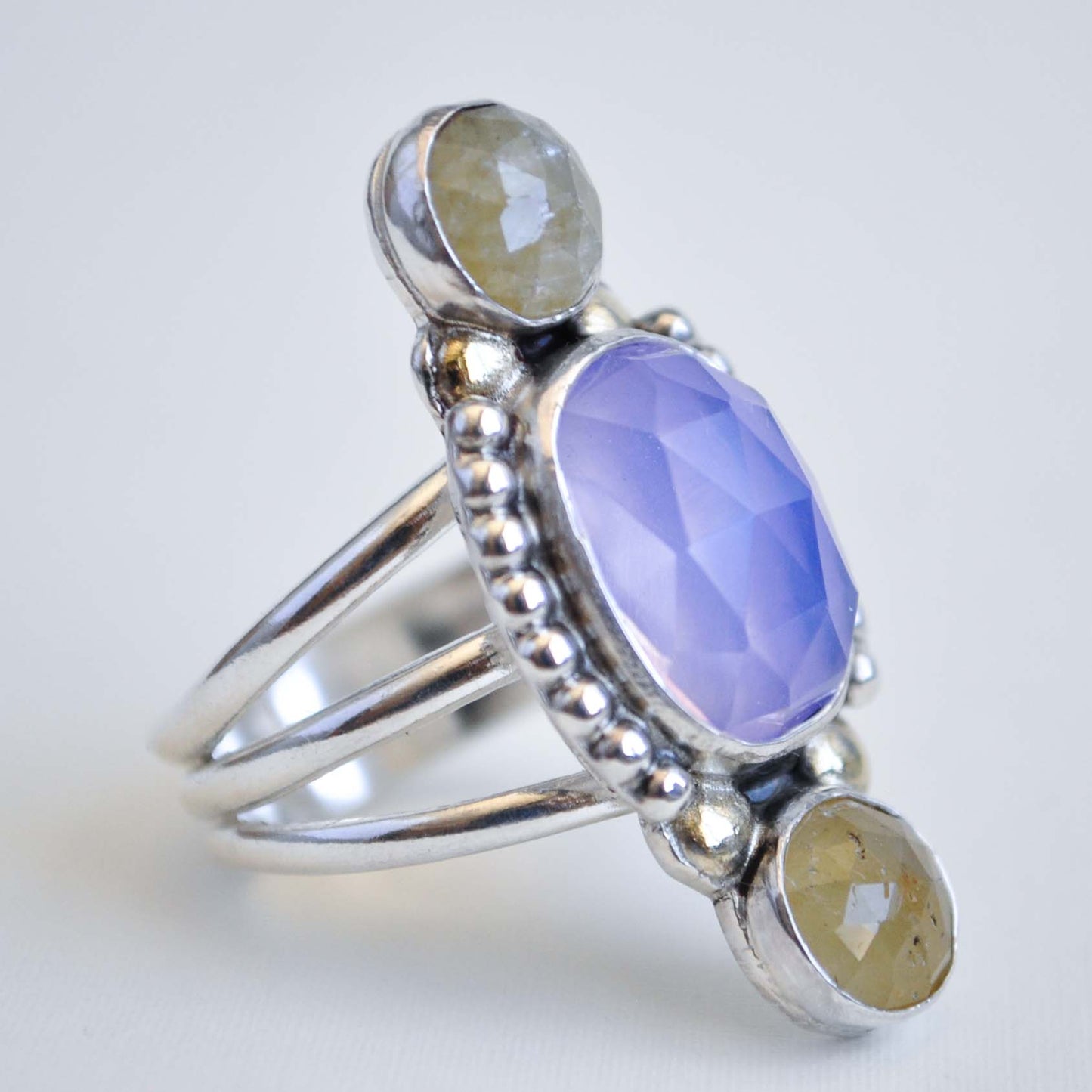 Silver ring with a purple gemstone on a white background
