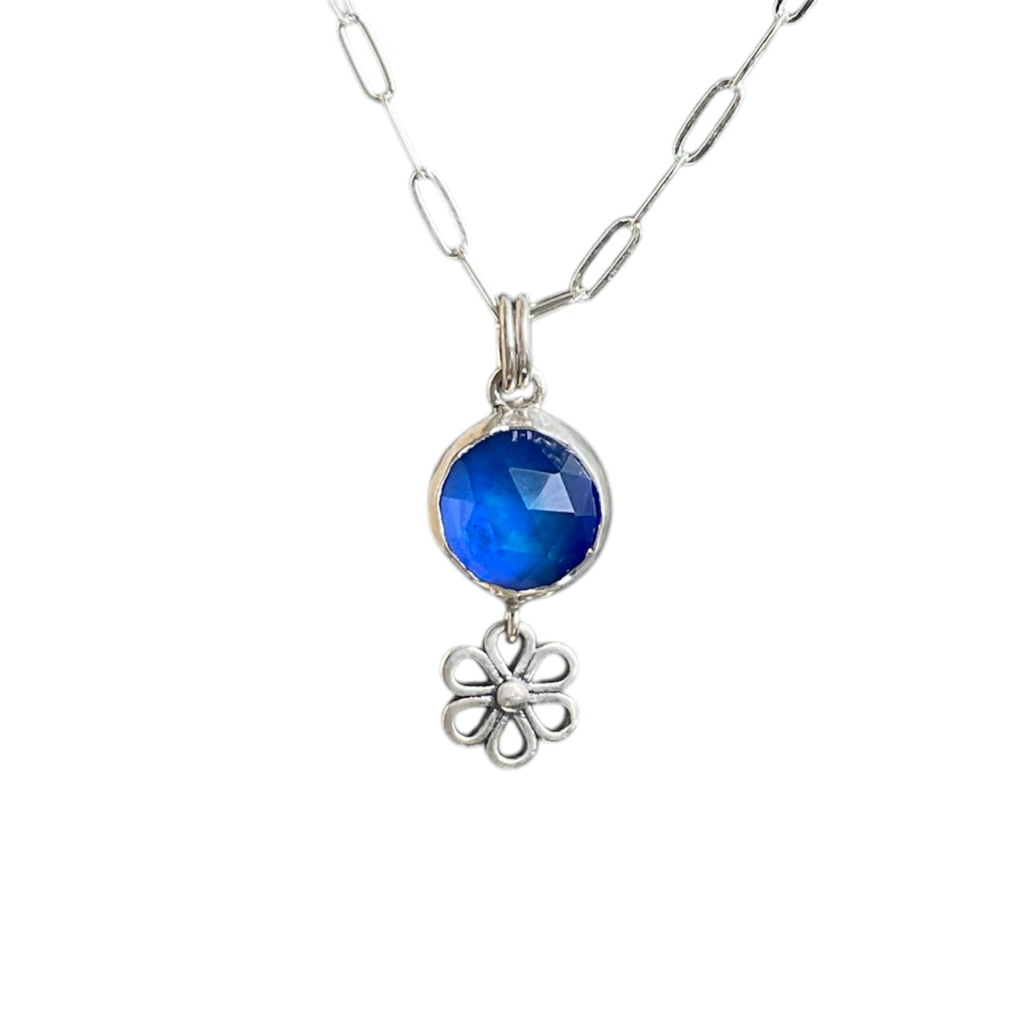 Open daisy drop charm underneath a faceted blue aurora opal gemstone. Silver setting on a sterling silver chain.