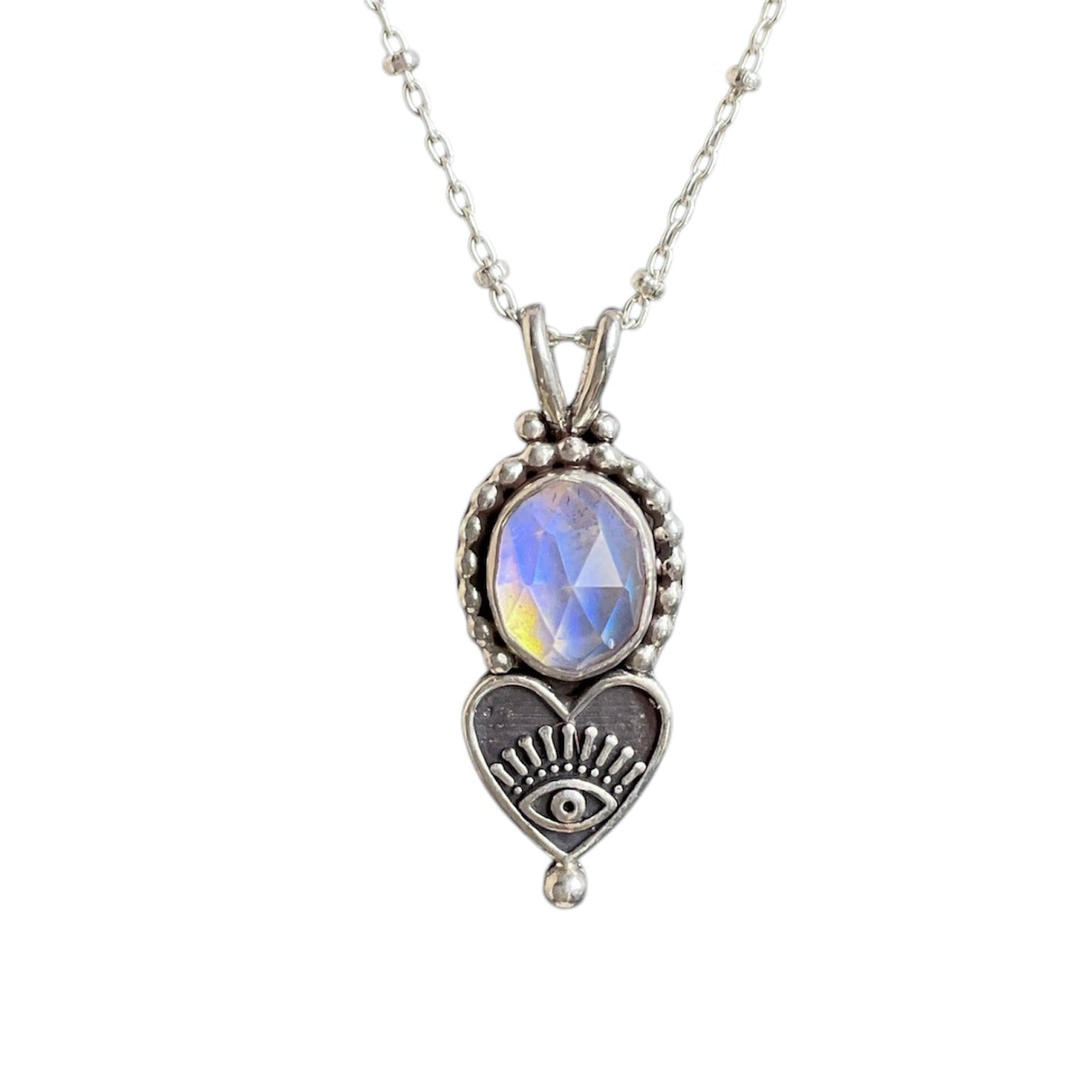 Oval aurora opal gemstone pendant with a beaded border and heart eye embellishment on a sterling silver chain