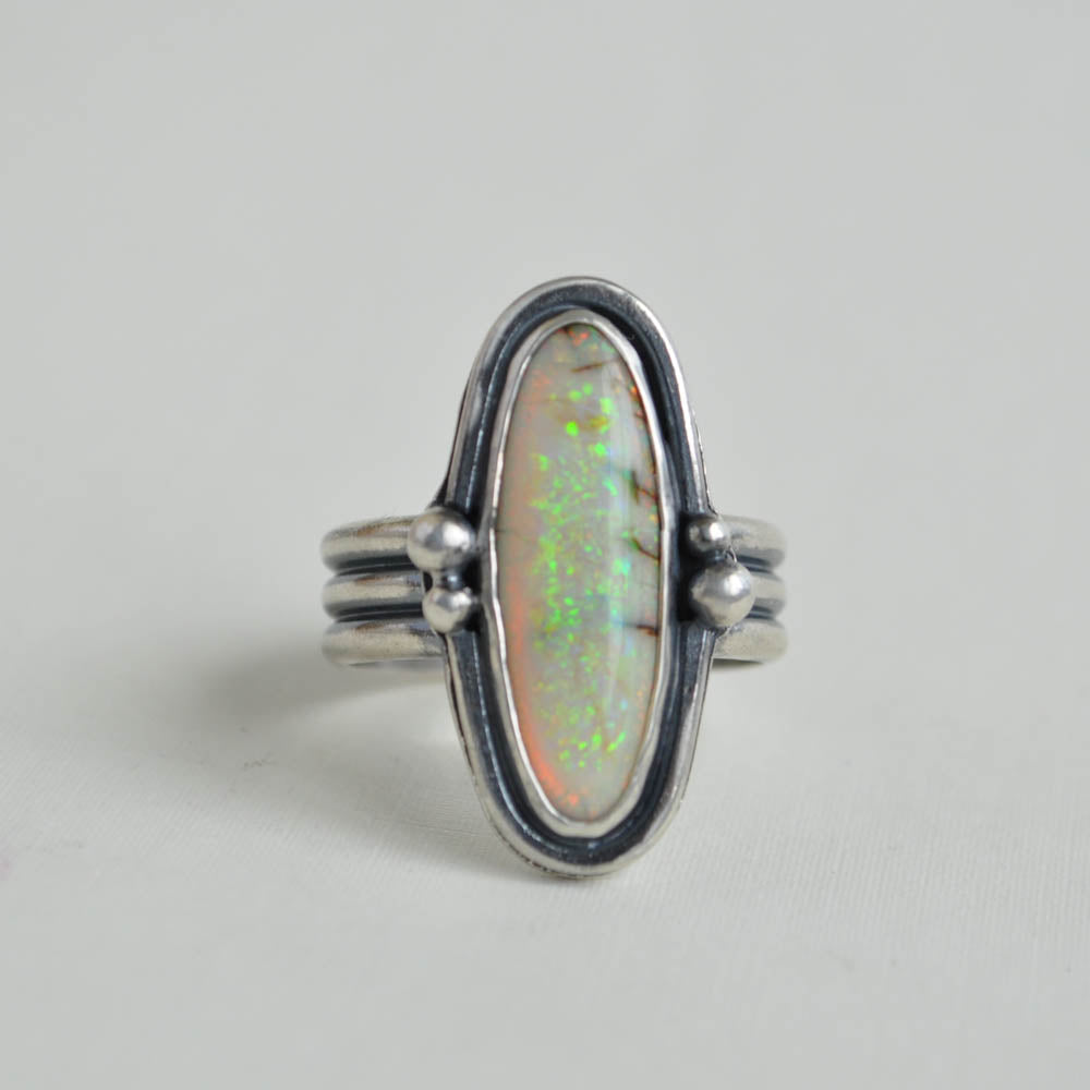 Green-yellow sterling opal gemstone bezel set in sterling silver on a triple half round band.