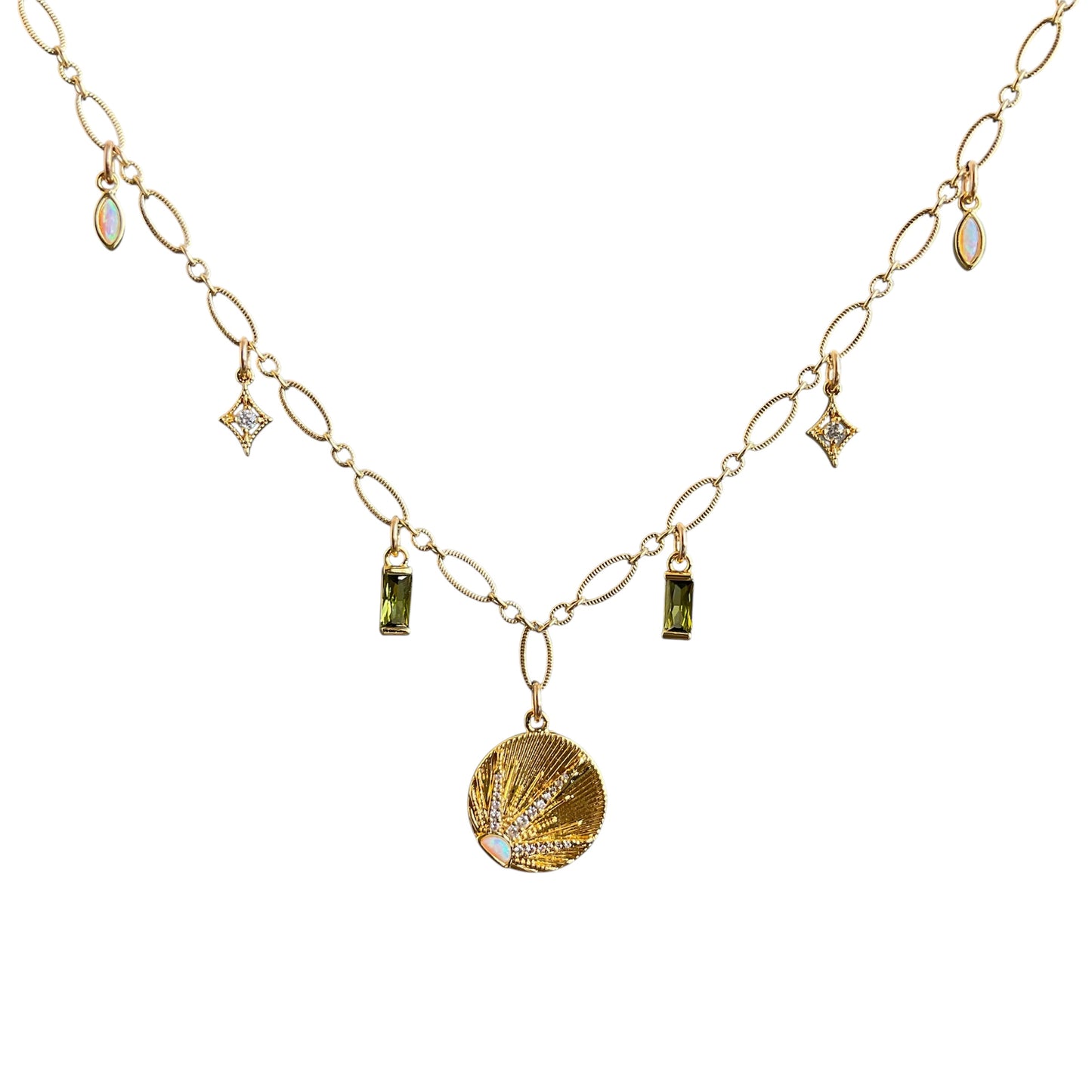 Gold necklace with shell pendant and green gemstones on a white background