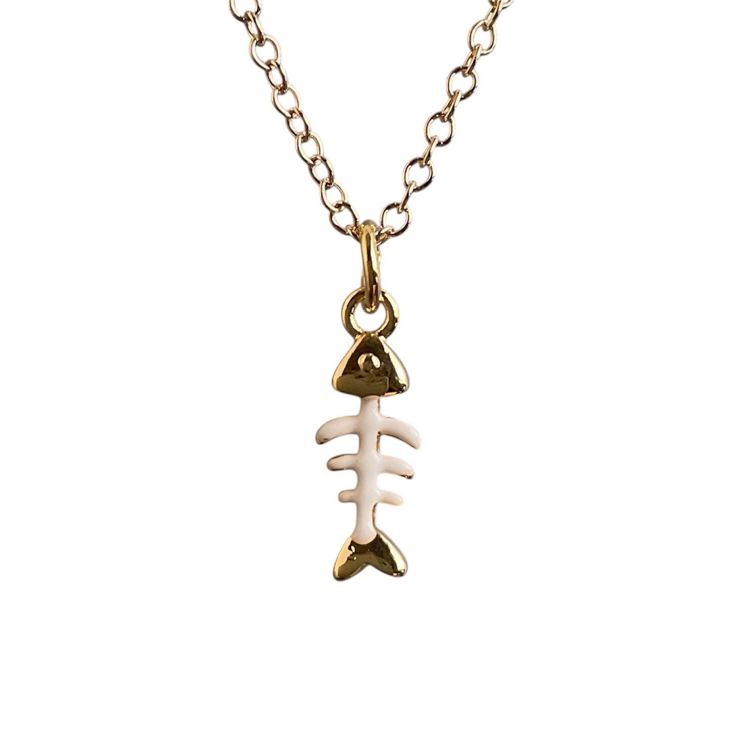 Gold and white fish bone pendant necklace on a white background