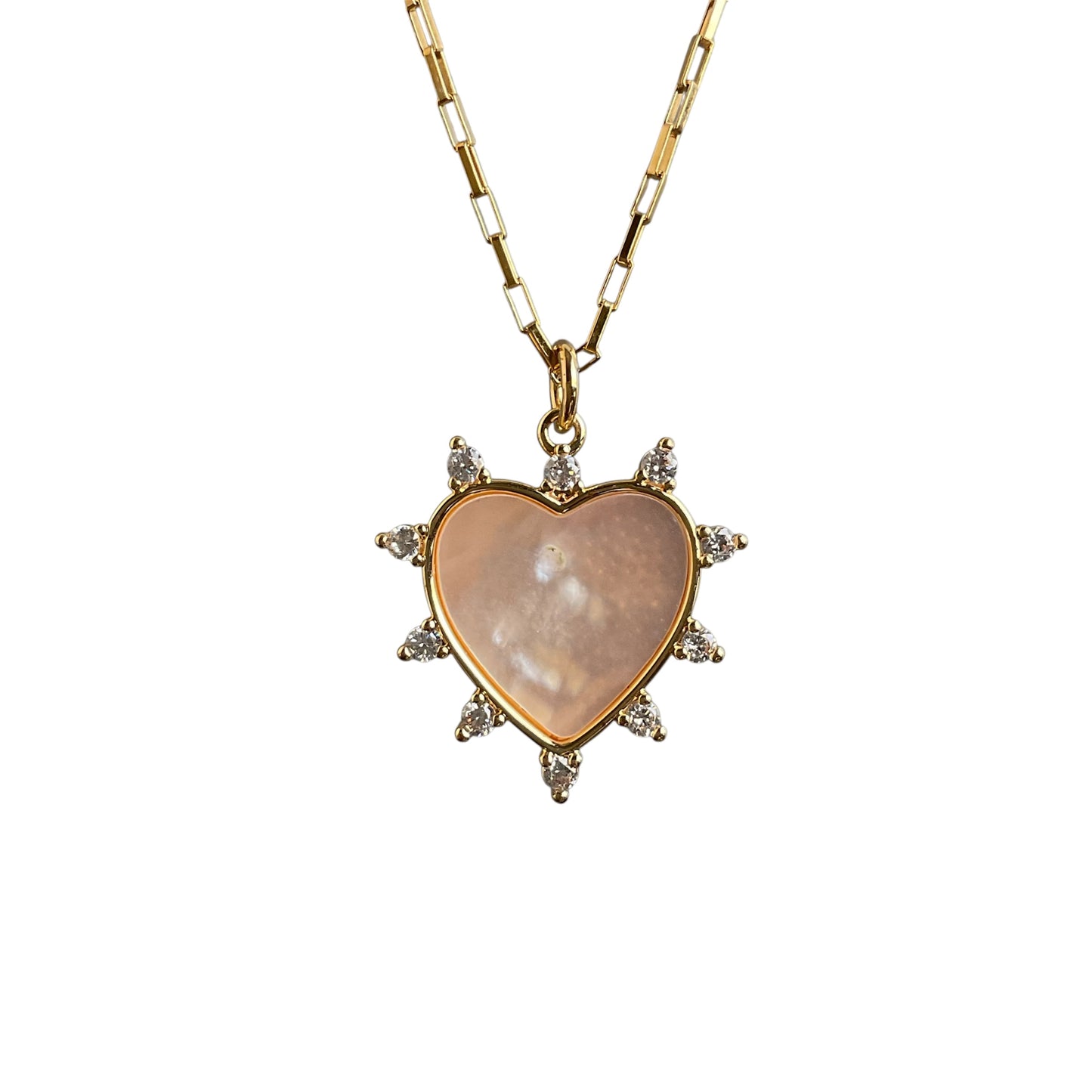 Heart-shaped pendant with a pearl center on a gold chain against a white background