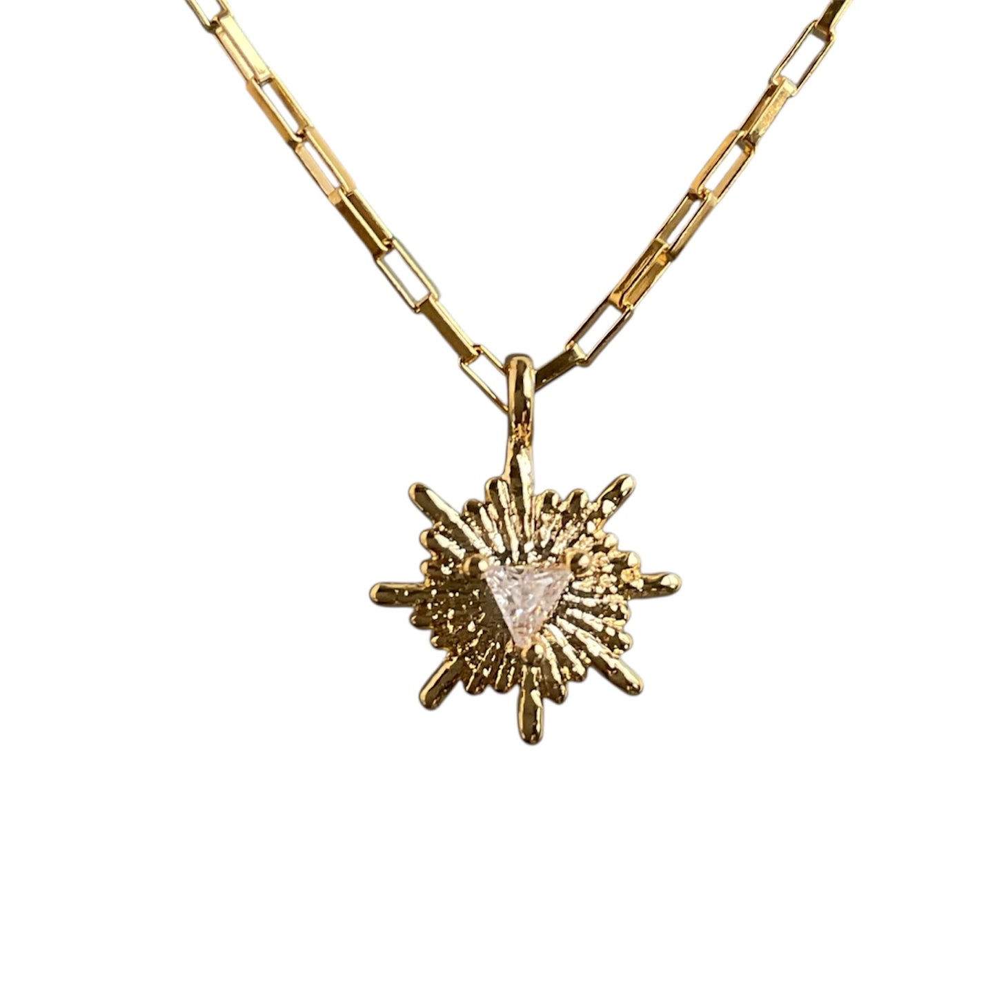 Gold necklace with a sun-shaped pendant on a white background