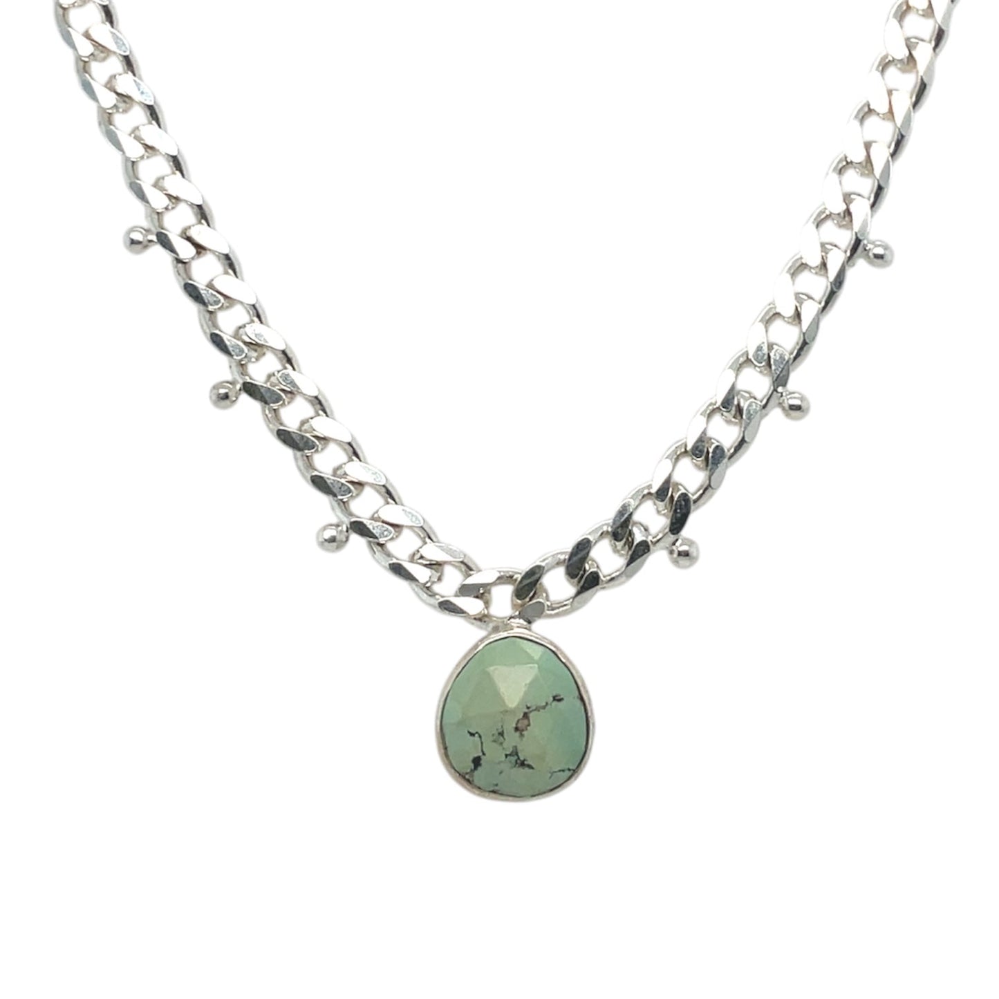 Faceted turquoise stone bezel-set in sterling silver on a cuban link chain studded with three delicate beads.