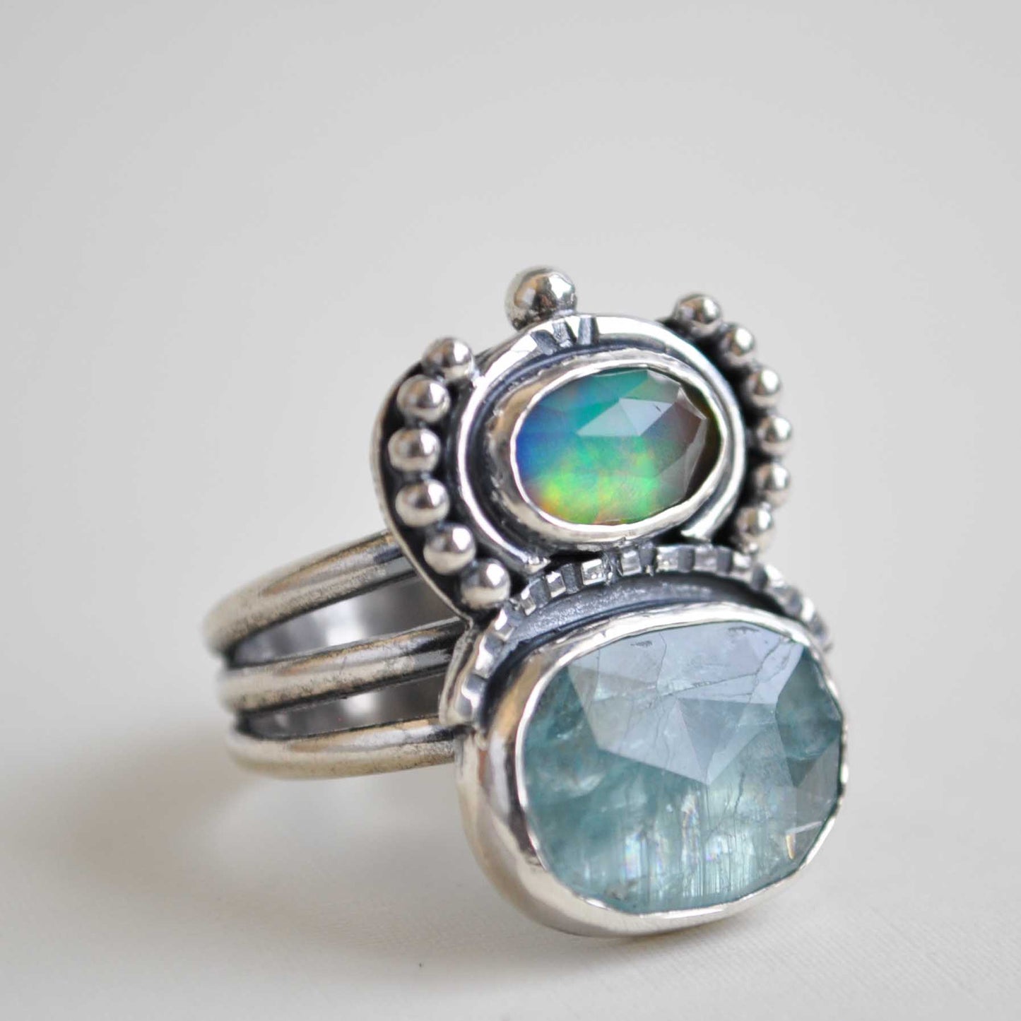 Two silver rings with gemstones on a light gray background