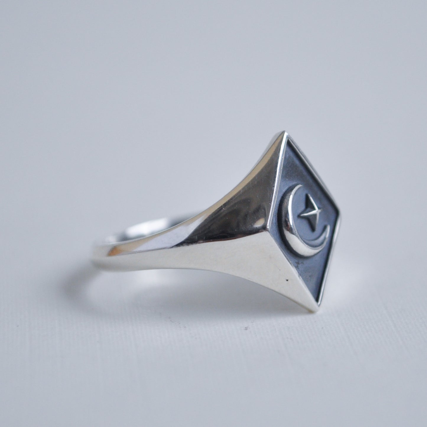 Silver ring with a geometric design on a light gray background