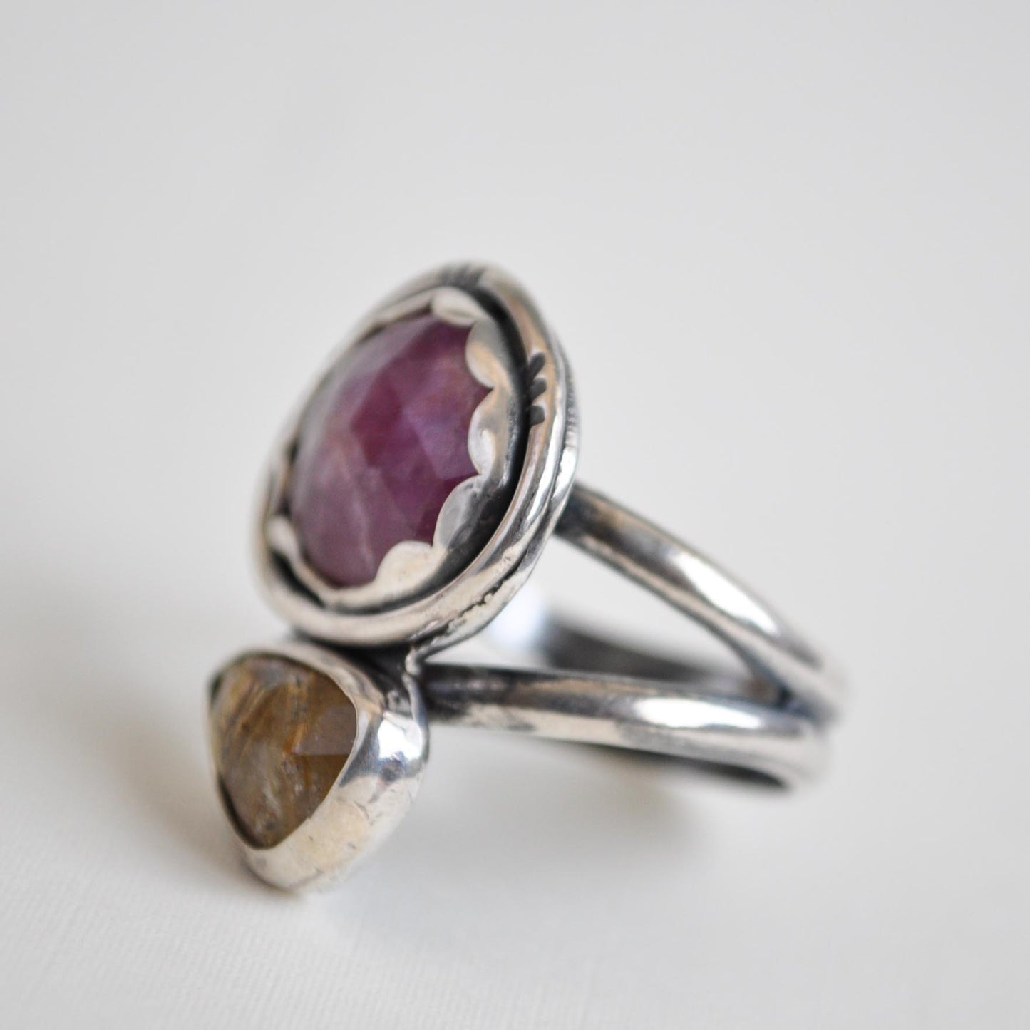 Silver ring with a purple gemstone on a white background