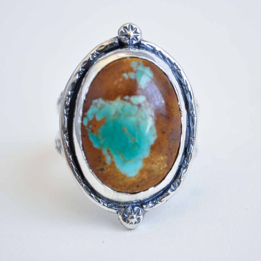 Ring with a large turquoise stone and silver setting on a white background