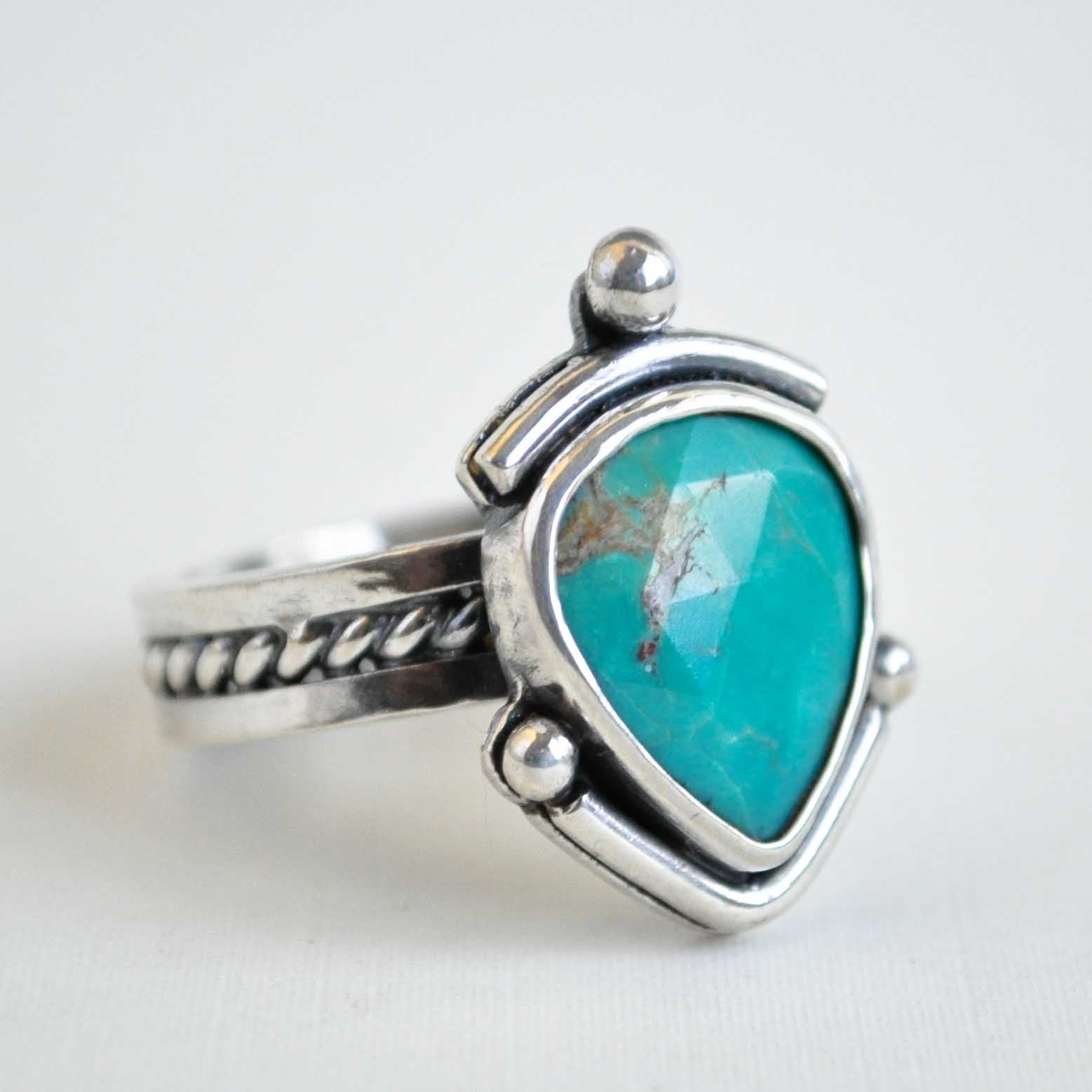 Silver ring with a turquoise stone on a white background