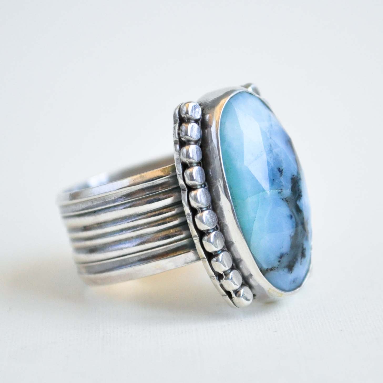 Silver ring with a large blue stone on a white background