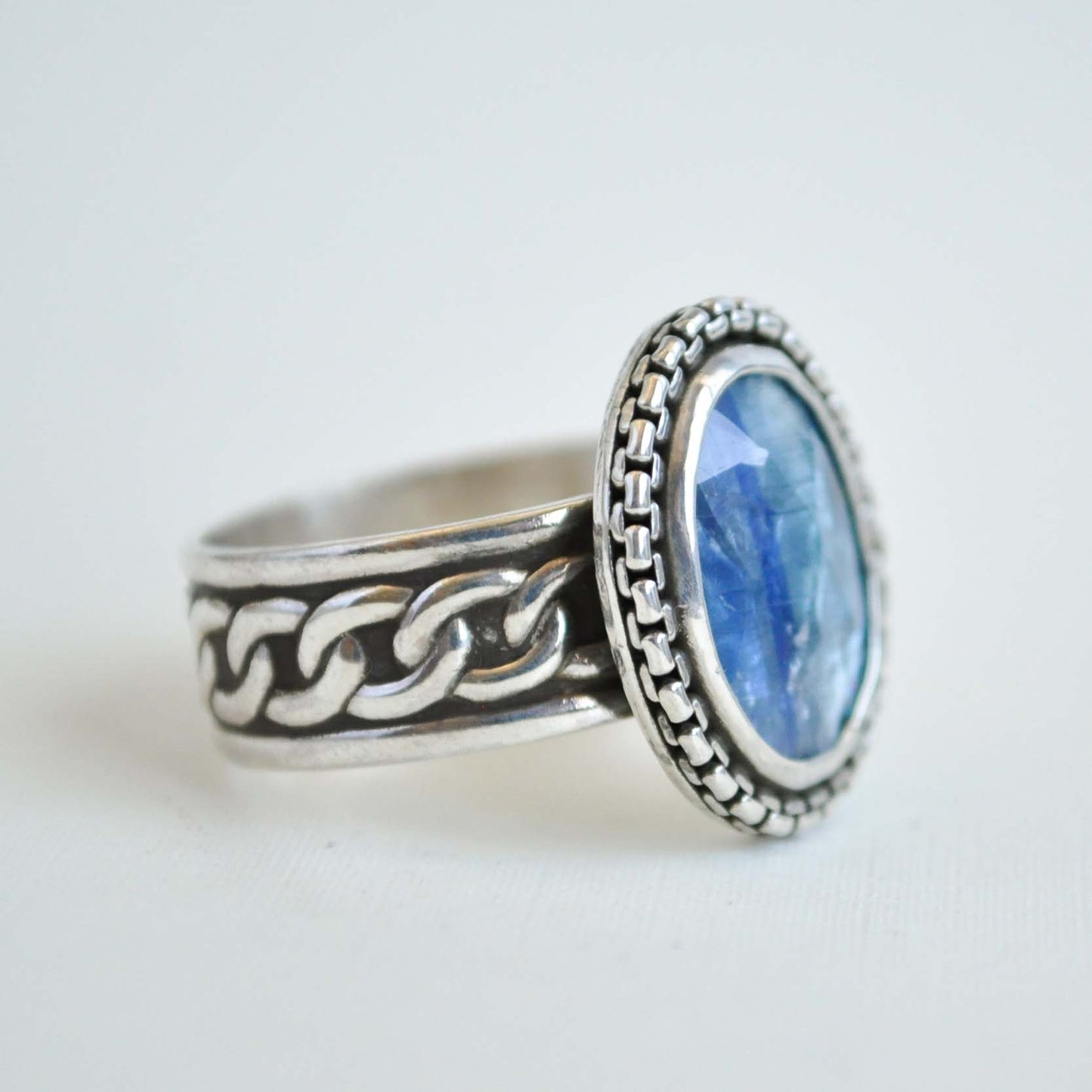 Silver ring with a blue stone on a white background