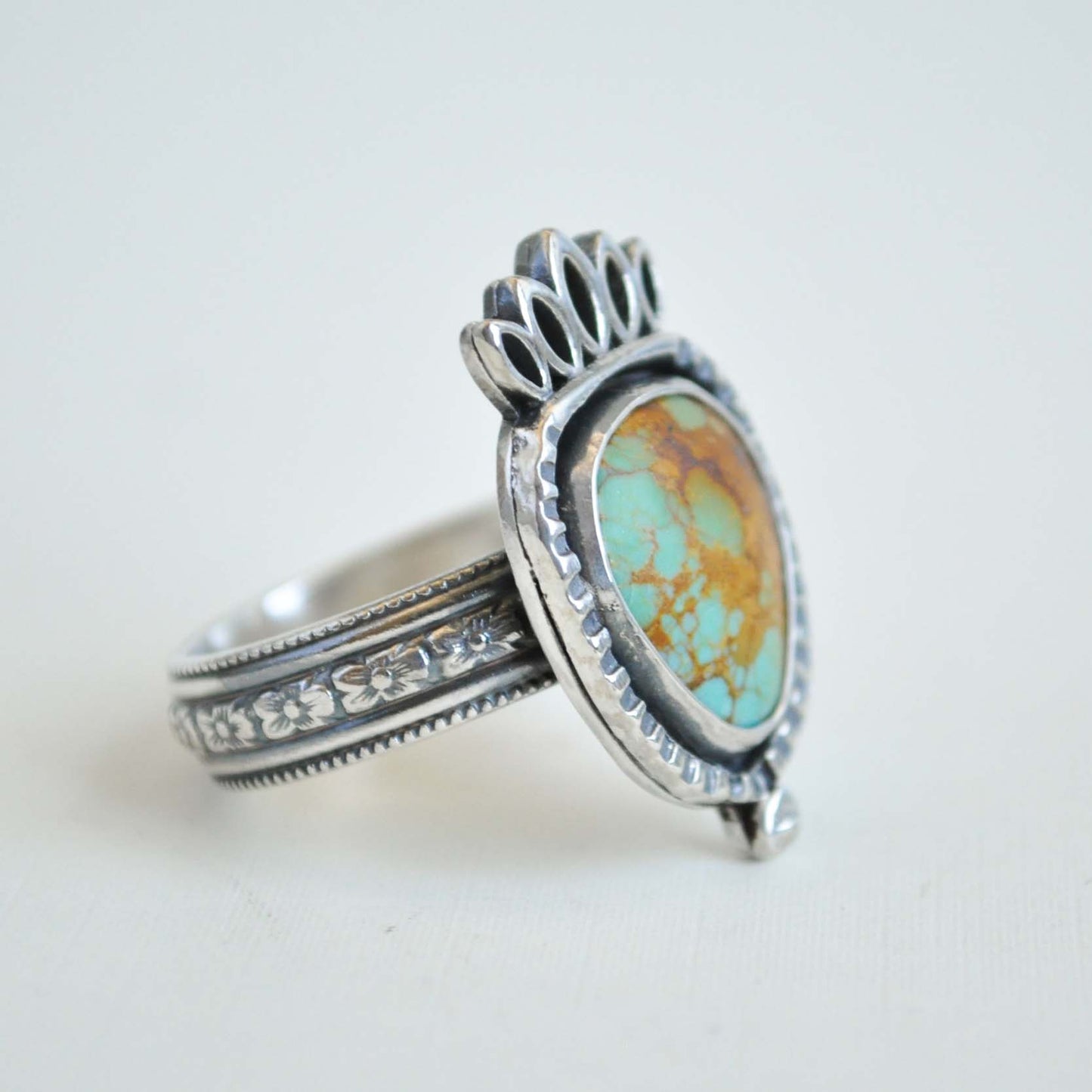 Silver ring with turquoise stone on a white background