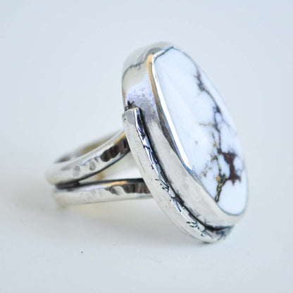 Silver ring with a white marbled stone on a light gray background