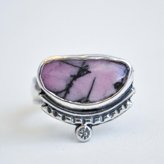 Silver ring with a pink stone on a white background