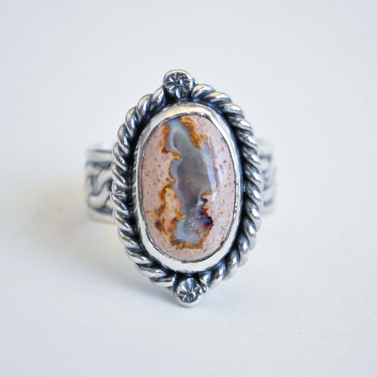 Silver ring with an oval stone on a white background