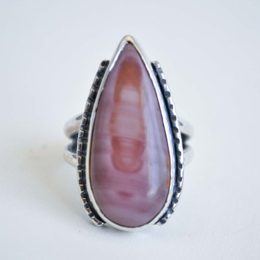 Ring with a large pink teardrop-shaped stone on a white background