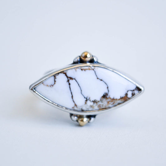 Marquise shaped gemstone ring with marble pattern on a white background