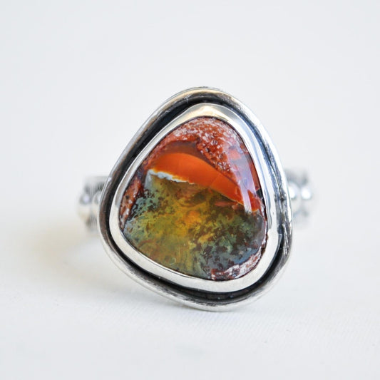 Silver ring with a colorful stone on a white background