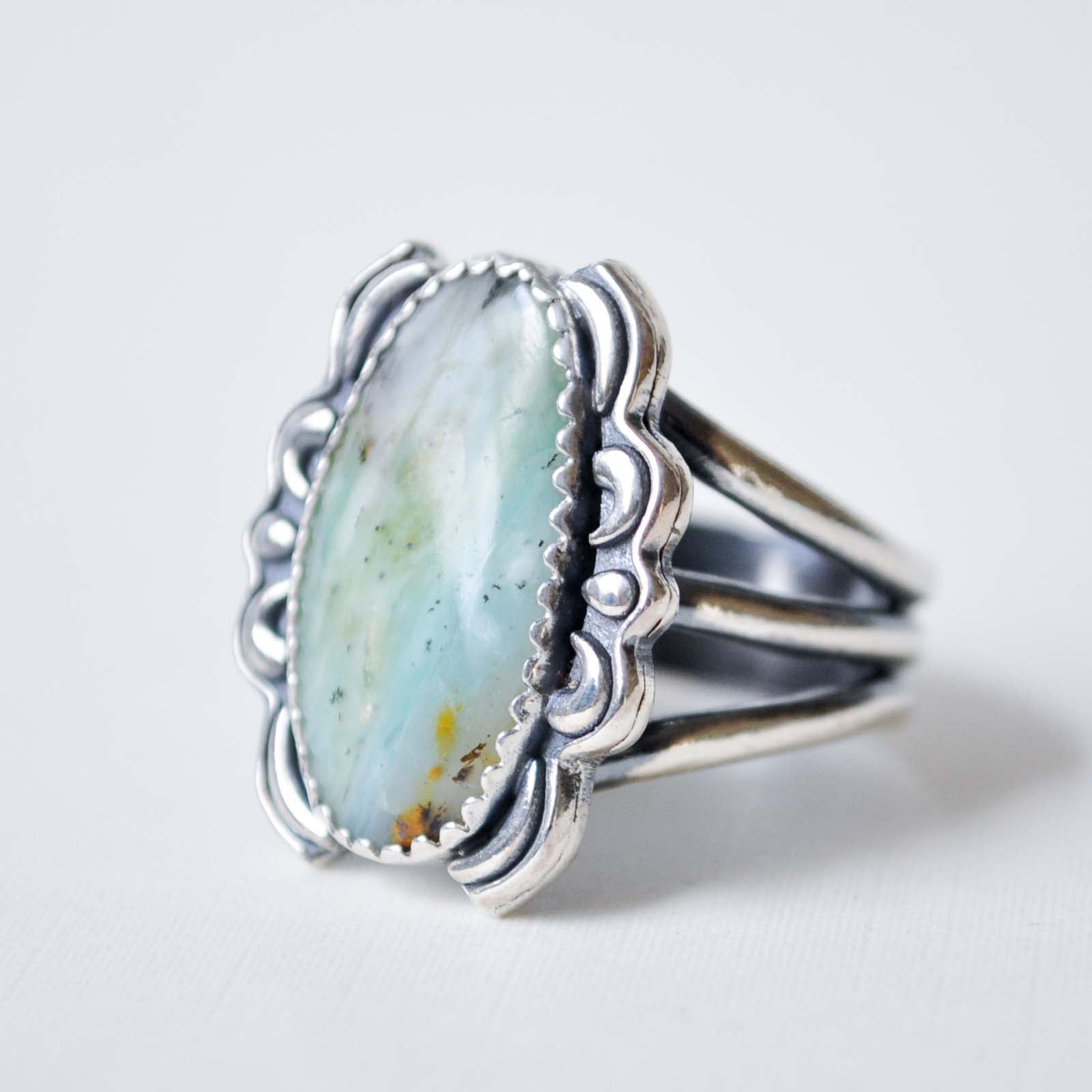 Silver ring with a large turquoise stone on a light gray background