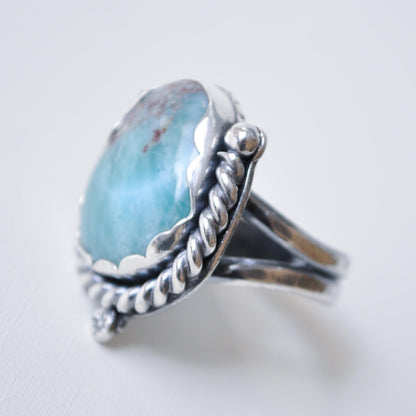 Silver ring with a large blue stone on a light background