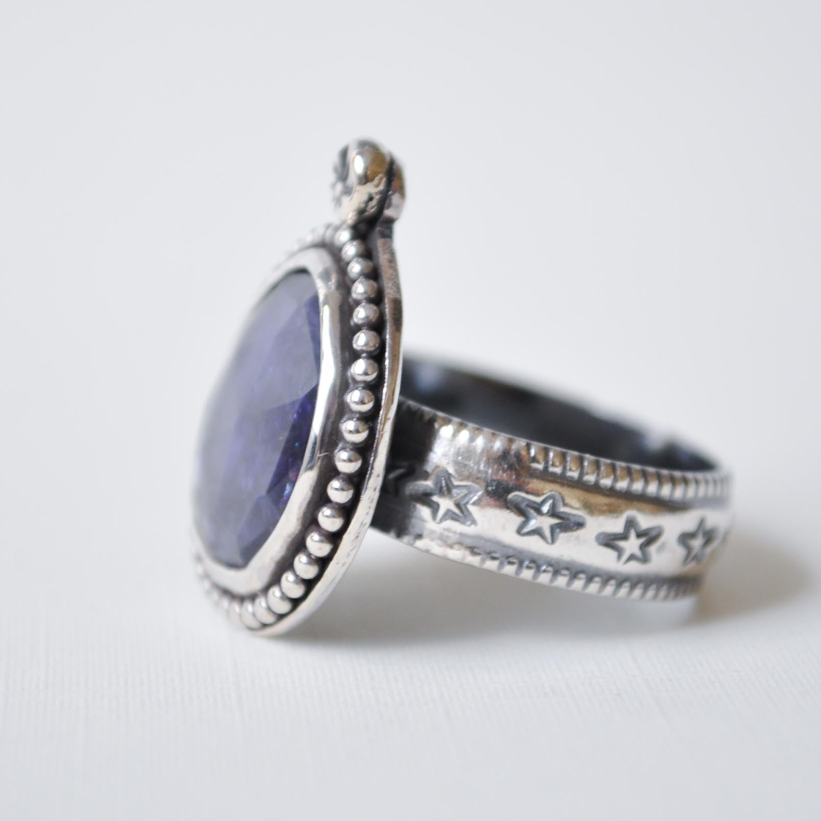 Silver ring with star designs on a white background