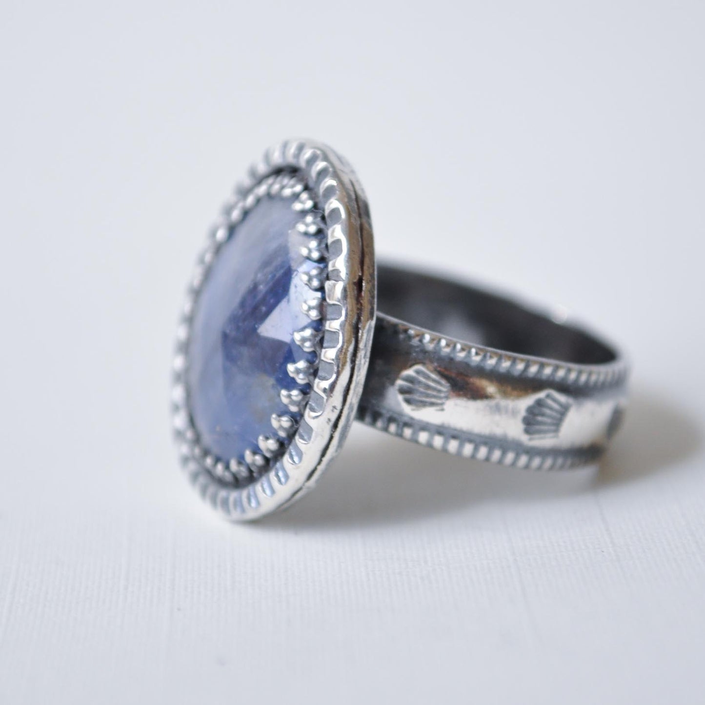 Silver ring with a blue stone on a white background