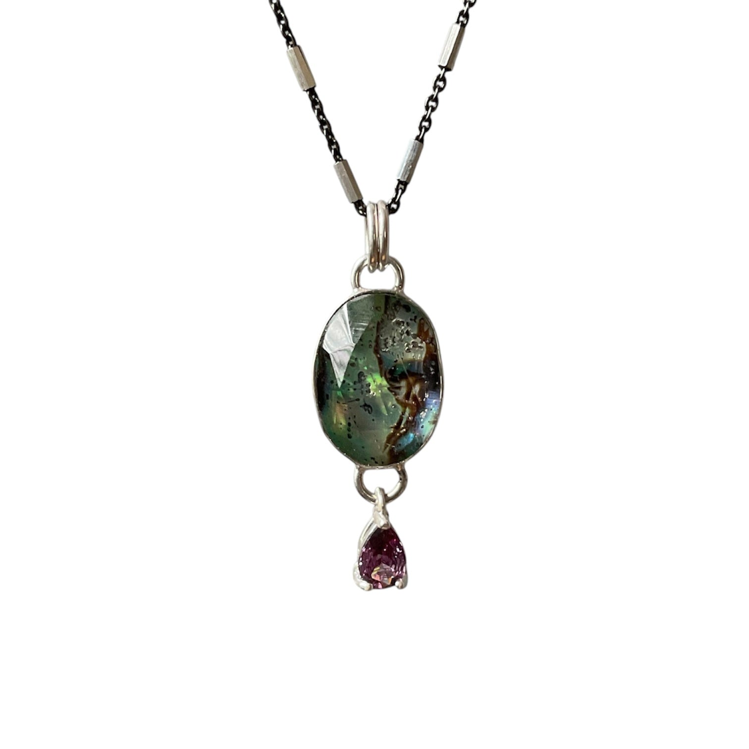 Necklace with a labradorite pendant and a small purple gemstone on a white background