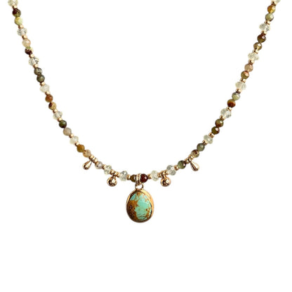 Turquoise gemstone hanging from a beaded necklace with chrysoprase and prehnite gemstones 