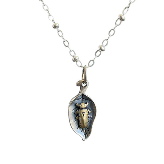 Brass beetle sleeping on a sterling silver leaf, on a satellite chain.