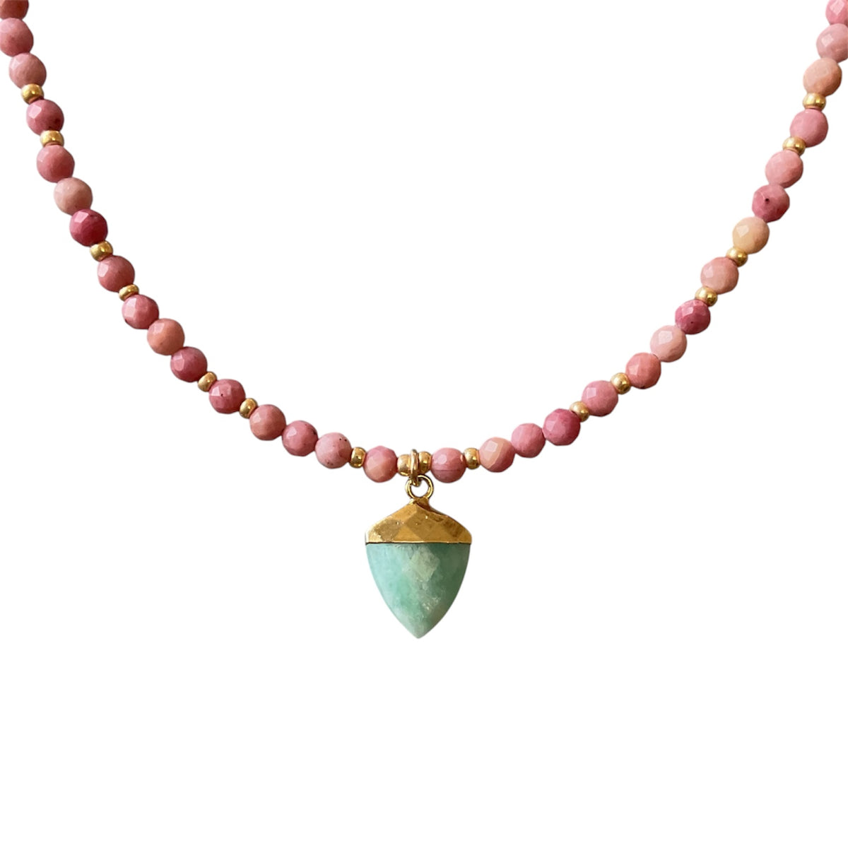 A beaded necklace featuring round pink beads separated by small gold spacer beads, with a faceted green teardrop pendant accented by gold caps at the top and bottom, shown against a plain white background.