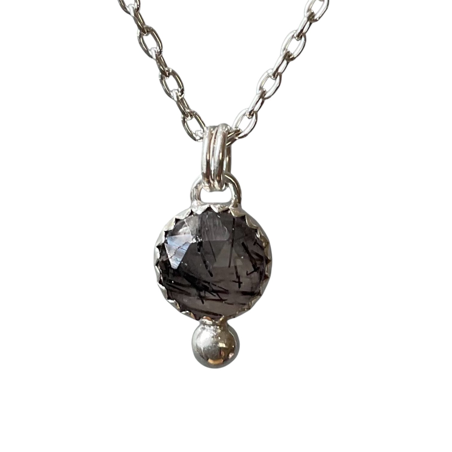 Necklace with a dark gemstone pendant on a white background