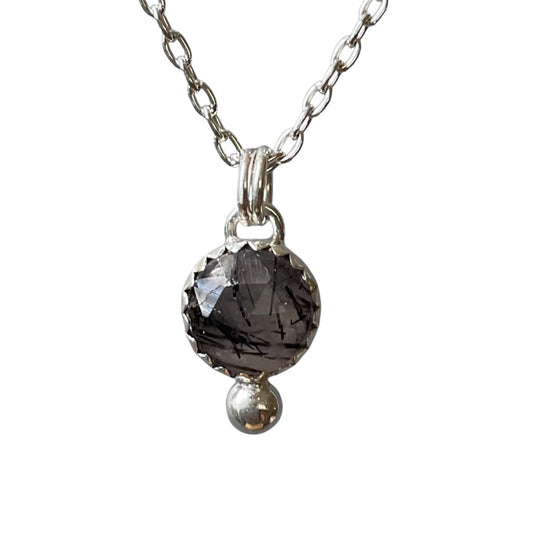 Necklace with a dark gemstone pendant on a white background