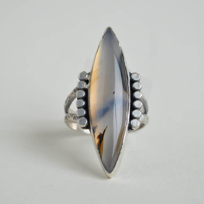 Long and large marquise shaped montana agate gemstone set in sterling silver with a patterned split band.
