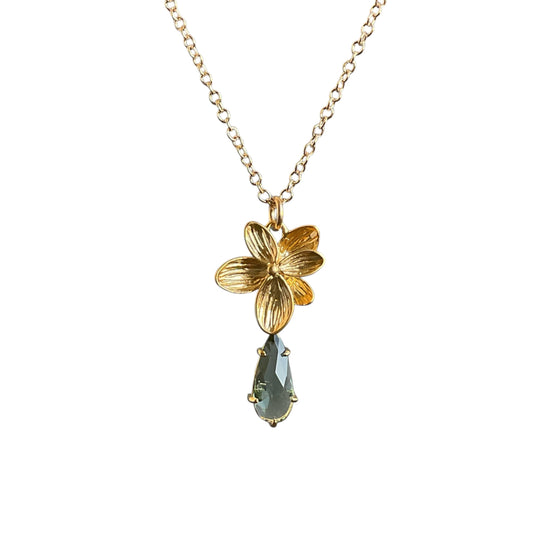 Gold orchid pendant with a green drop underneath on a gold chain.