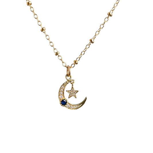 Small moon and dangling star charm on a gold chain