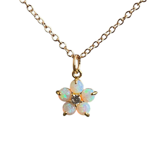 Flashy round opals make up the petals of a forget me not flower. Pendant on a gold chain. 