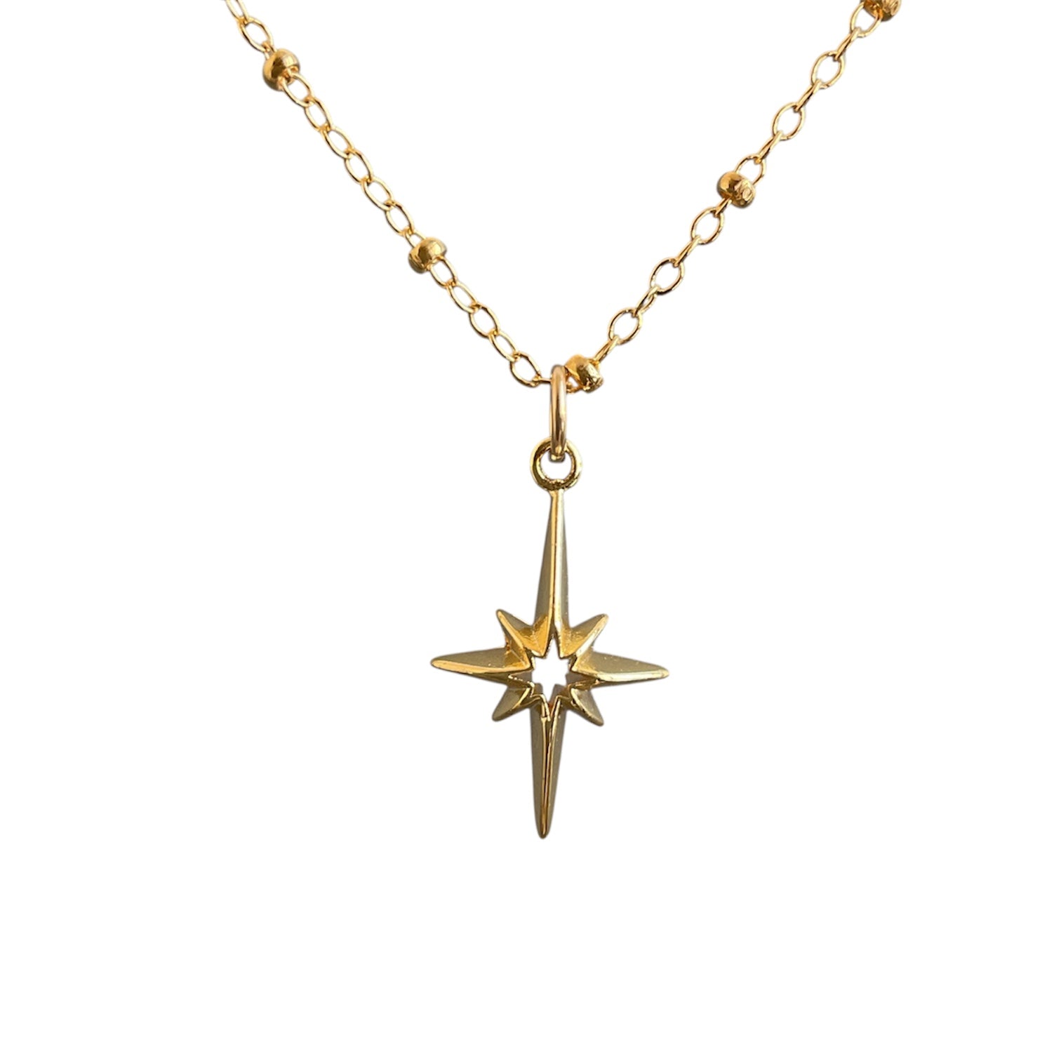 Gold necklace with a star-shaped pendant on a white background