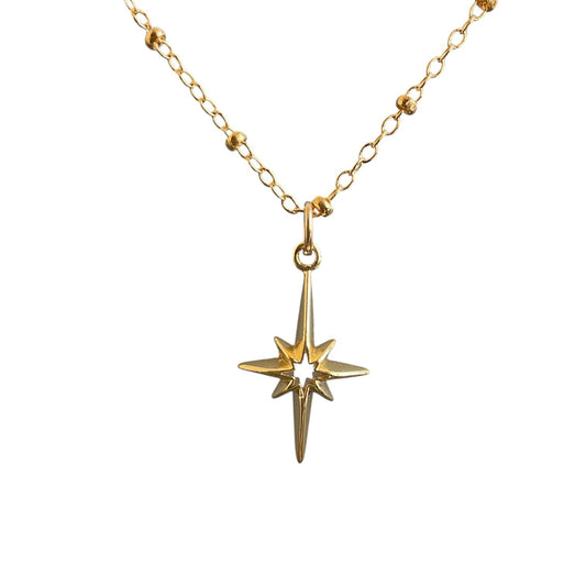 Gold necklace with a star-shaped pendant on a white background