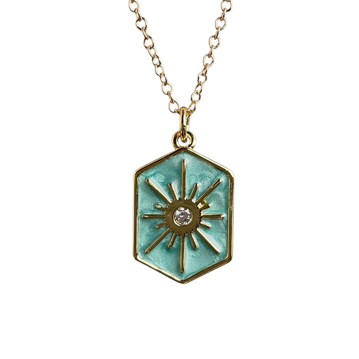 Hexagonal pendant with sun design and turquoise enamel on a gold chain against a white background