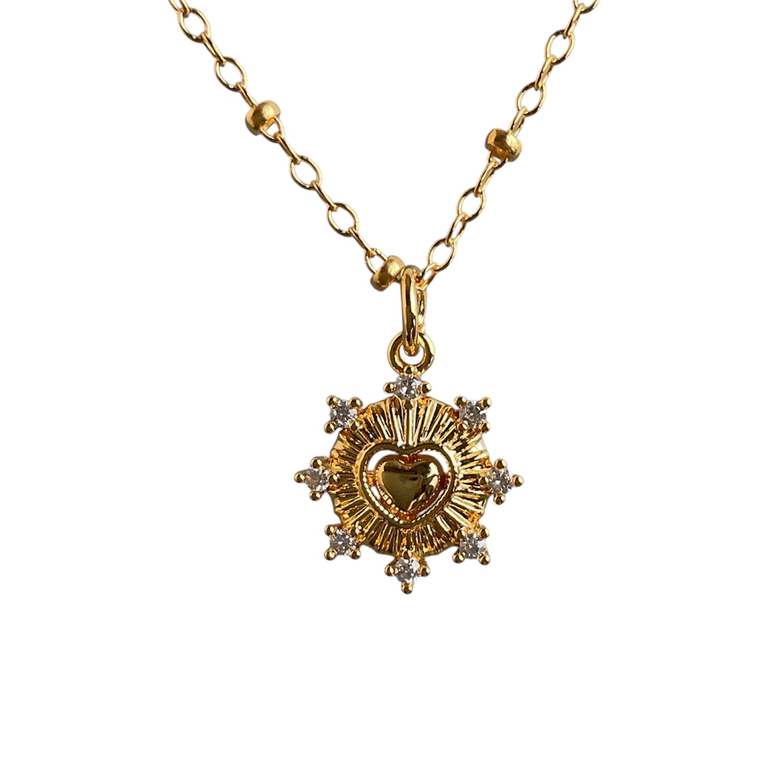 Gold necklace with a heart-shaped pendant on a white background