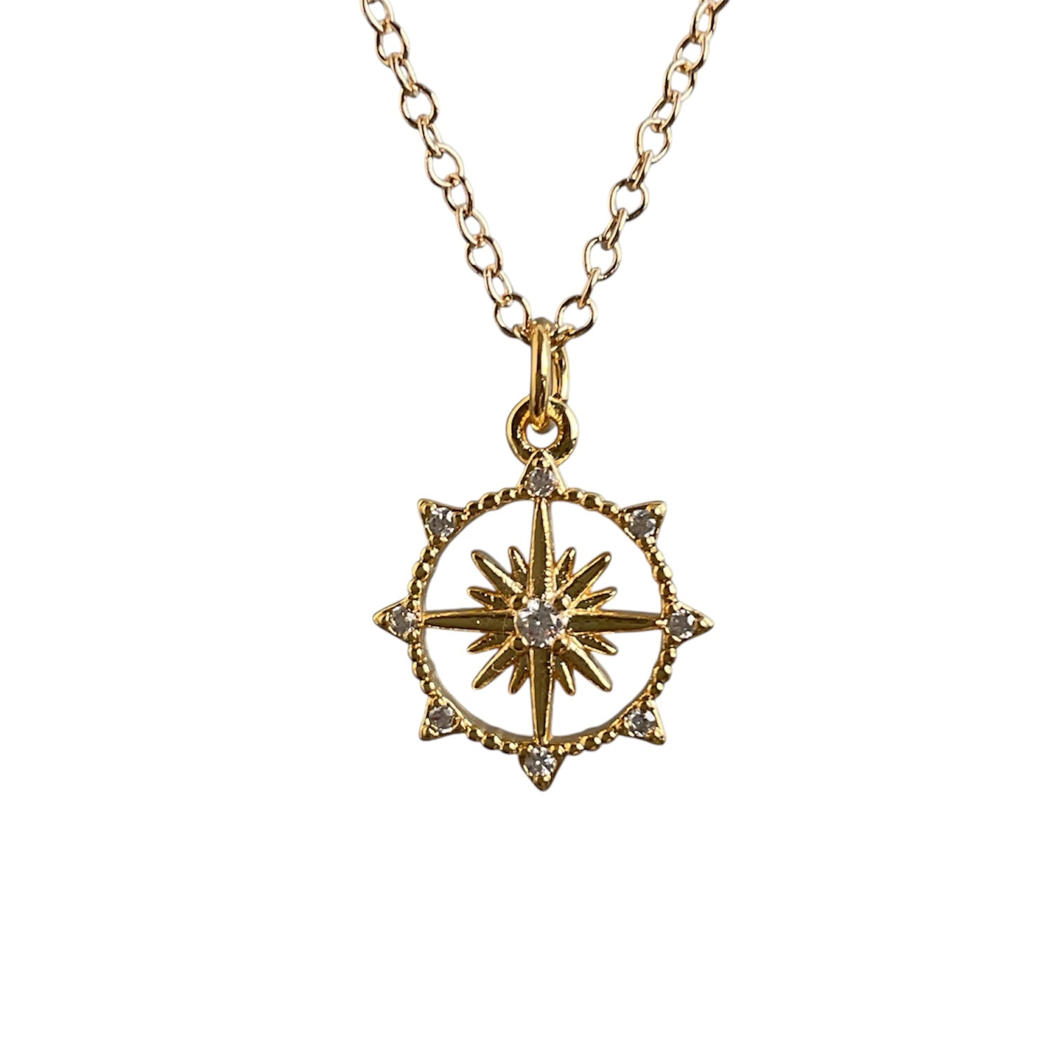Gold necklace with a star-shaped pendant on a white background