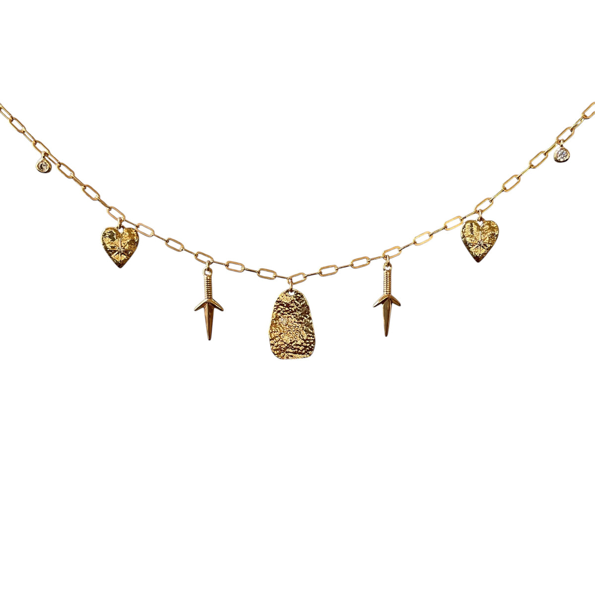 A gold-tone chain necklace featuring five dangling charms: two textured heart pendants, two dagger-like pendants, and one textured shield pendant, displayed against a solid white background.