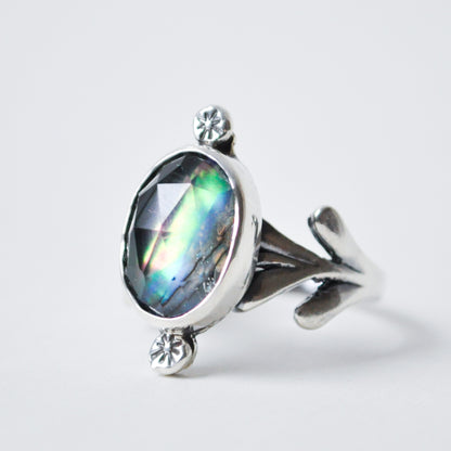 Silver ring with a large gemstone on a light gray background