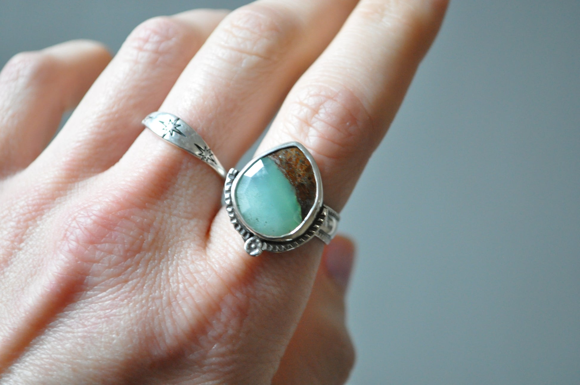 Chrysoprase ring on a finger with a blurred background