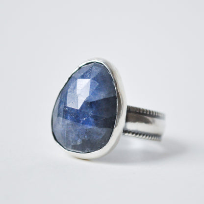 Silver ring with a large blue stone on a white background